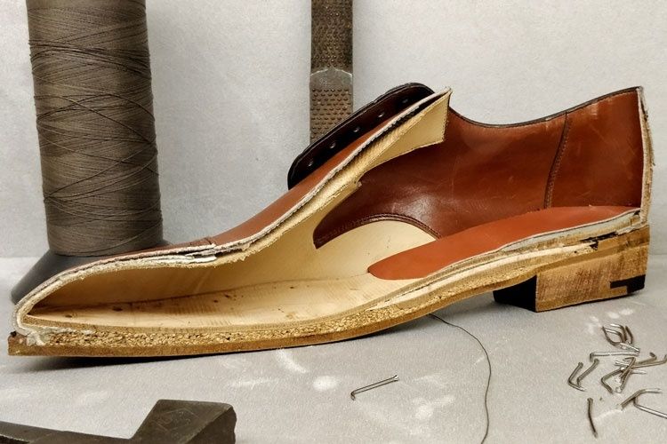 Cross-sectioned leather shoe showing layered sole construction and welt