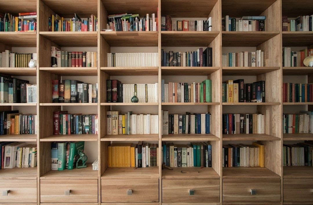 Wall-to-wall wooden bookcase filled with books and small decor